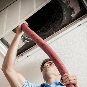 image of a man cleaning air ducts